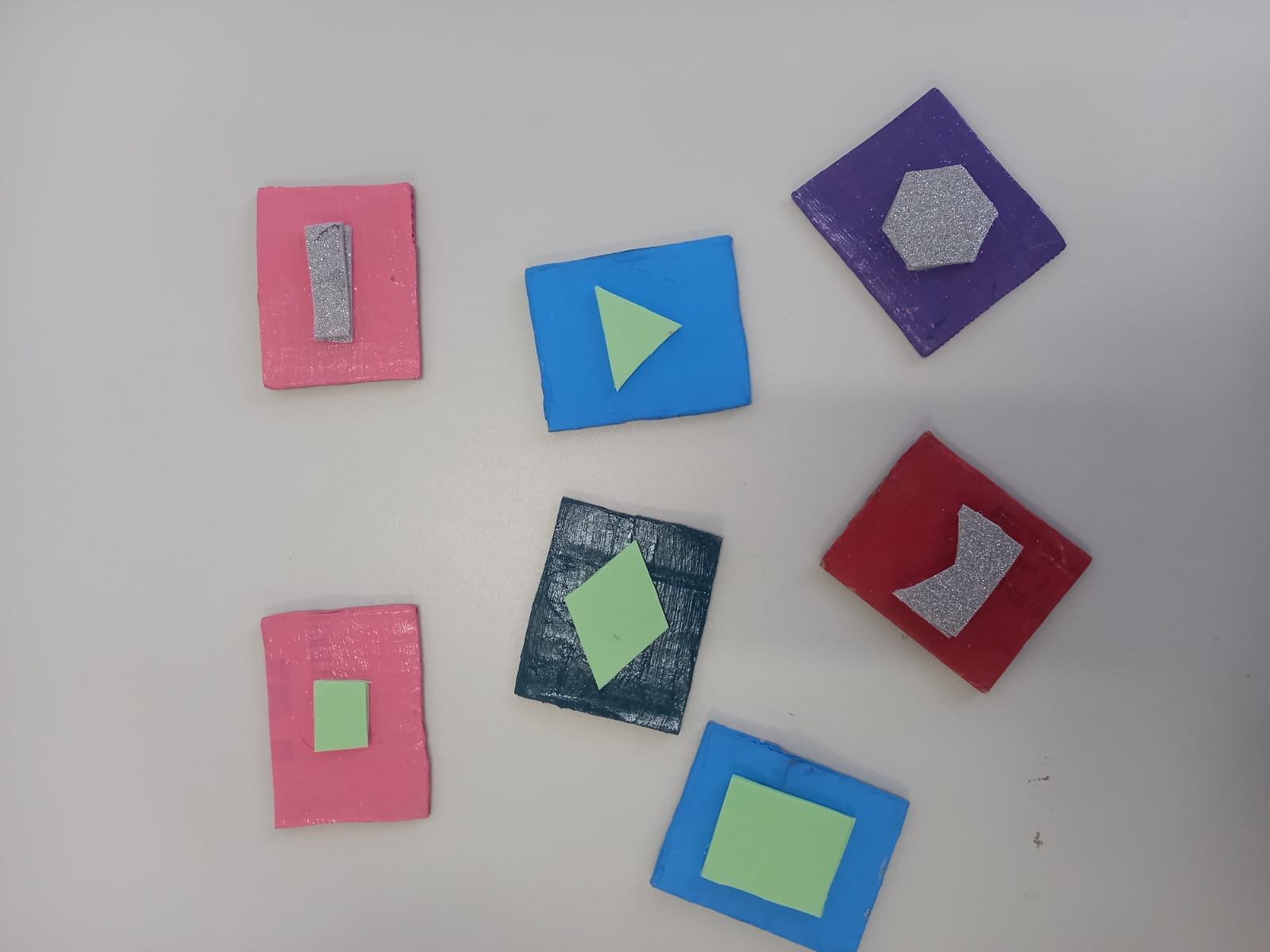 7 figuras quadradas com diferentes formas geométricas no centro